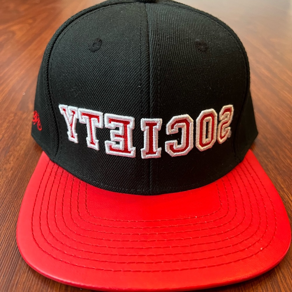 Society snap back hat with red faux leather brim